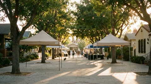 String lights and empty vendor canopies in an outdoor community courtyard at golden hour in Mar Vista