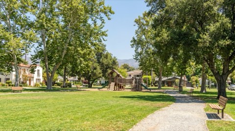 A sunlit neighborhood park in Mar Vista with a play structure, shade trees, and open lawn