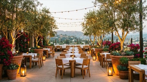 An upscale outdoor restaurant patio at golden hour with string lights and empty tables
