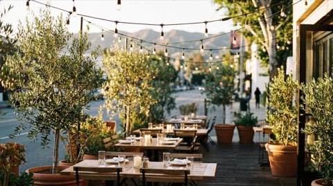 An outdoor restaurant patio with string lights along Ventura Boulevard in Studio City at golden hour