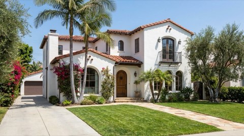 A Spanish Revival style single-family home in Beverlywood with a manicured lawn in midday light