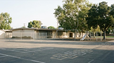 An empty elementary schoolyard near Beverlywood with a playground and shade trees on a quiet morning