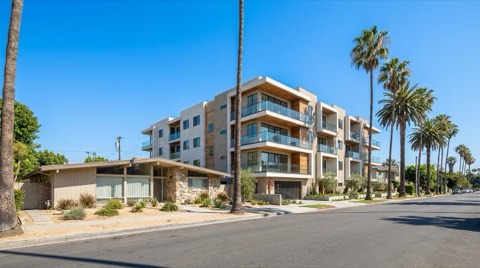 A contemporary condo building next to a mid-century single-family home on a Studio City street