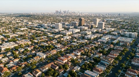 An elevated view over Culver City rooftops toward the surrounding hills and downtown.