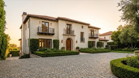An upscale Spanish colonial revival home in Los Feliz with wrought iron balconies and a terracotta roof at golden hour