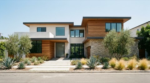 An upscale single-family home exterior with contemporary architecture and clean landscaping under a clear midday sky