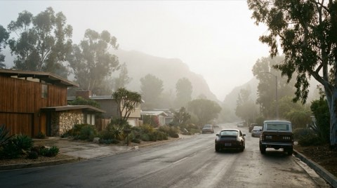 A hazy morning residential street in Studio City with cars heading toward a canyon pass