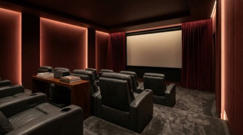 Private home theater with tiered leather seating and ambient lighting