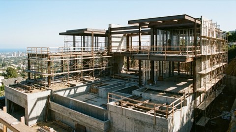 A brand-new modern estate under construction on a Bel Air hillside lot with exposed steel framing and scaffolding