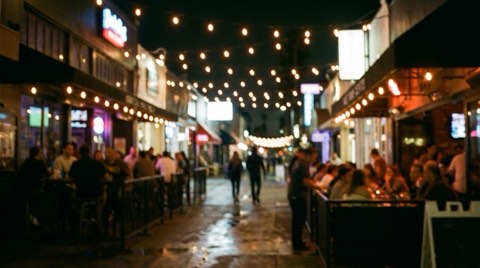 A lively Venice boutique street at night with glowing string lights