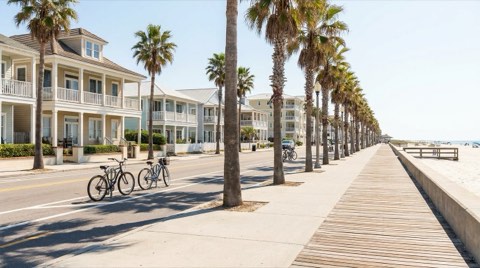A pedestrian-friendly coastal street with a bike lane and parked bicycles near a boardwalk