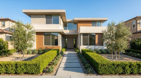 A tidy modern home exterior with symmetric landscaping and neat, orderly lines under bright daylight.