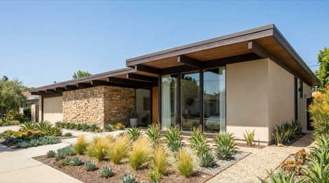 A mid-century modern Santa Monica house facade with horizontal lines, large glass windows, exposed wood beams, and drought-tolerant landscaping