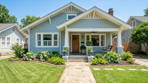 A beautifully staged single-family home exterior with freshly painted trim and clean landscaping in bright midday light