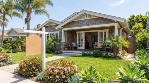 A staged Venice bungalow exterior with a blank yard sign and fresh landscaping