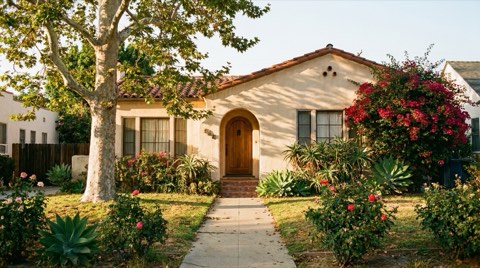 An older, well-loved traditional Beverlywood home with mature landscaping in warm late-afternoon light