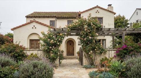 A weathered but well-loved Spanish revival home exterior in Santa Monica with mature rose bushes
