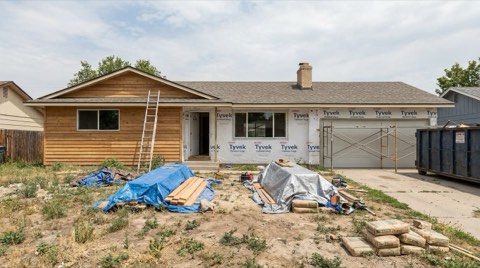A ranch home in Mar Vista mid-renovation with a ladder and tarps in the yard
