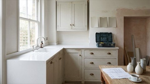Kitchen mid-renovation with paint swatches and a toolbox on the counter
