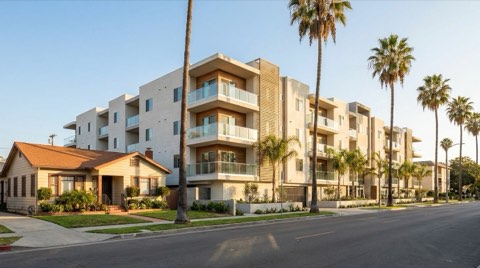 A modern apartment building exterior on a Studio City street next to a single-family home