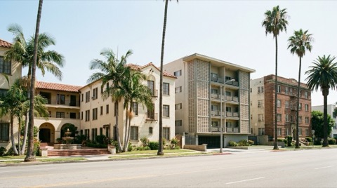 Row of multi-unit apartment buildings on a dense Los Angeles street