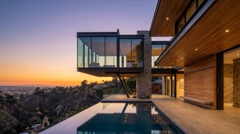 A modern view home in the hills above Studio City with glass walls overlooking a canyon at sunset