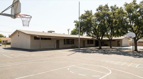 A modest neighborhood elementary school building near Beverlywood with an empty playground in bright daylight