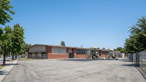 A generic elementary school building exterior in a Studio City residential area with an empty playground