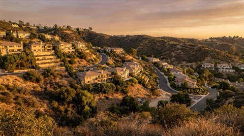 Hillside Los Angeles neighborhood bordered by dry chaparral in late afternoon light
