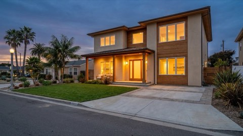 A welcoming modern single-family home exterior in Santa Monica glowing with warm porch light at dusk